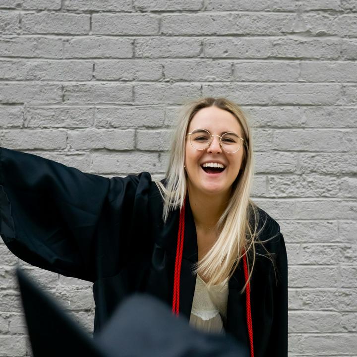 A graduate laughing in her gown